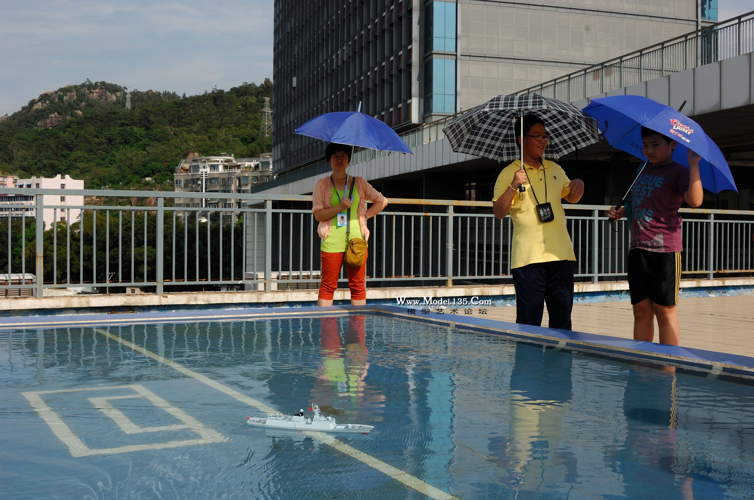 中午才下过暴雨，怎料下午骄阳似火，老师们都打起伞。