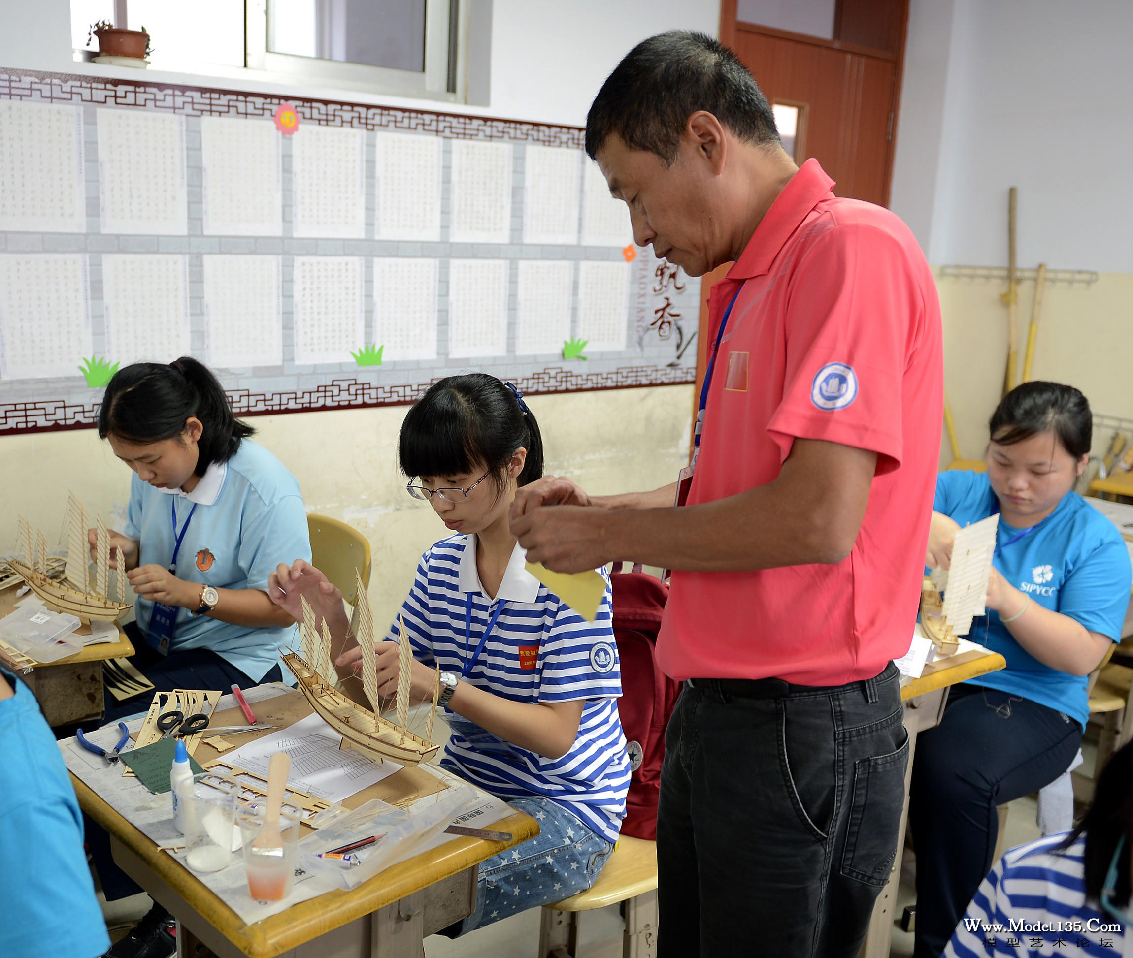 裁判员正在给选手们制作的模型贴上打分使用的编号