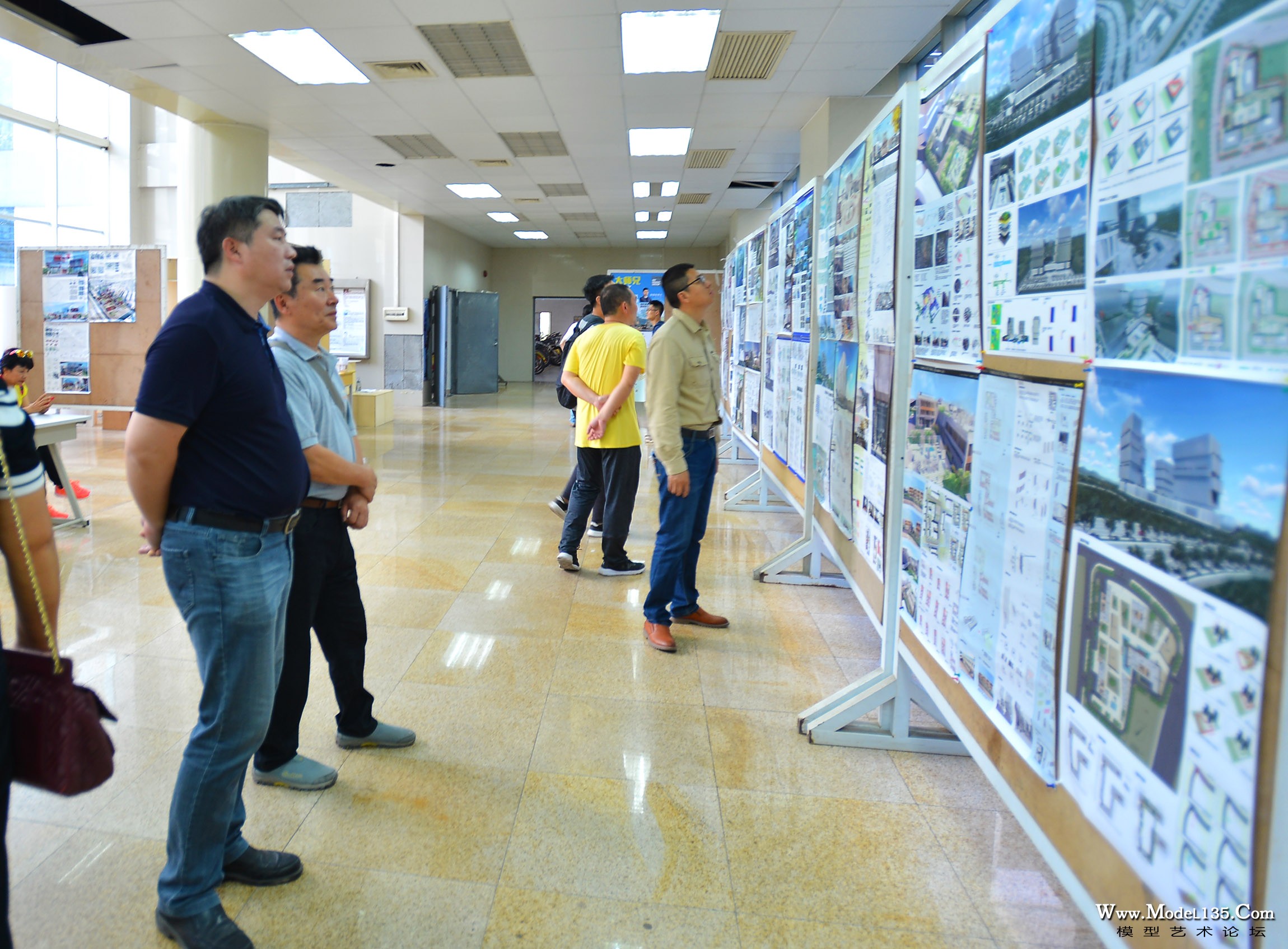 裁判员们正在参观大学生的建筑设计图样展示