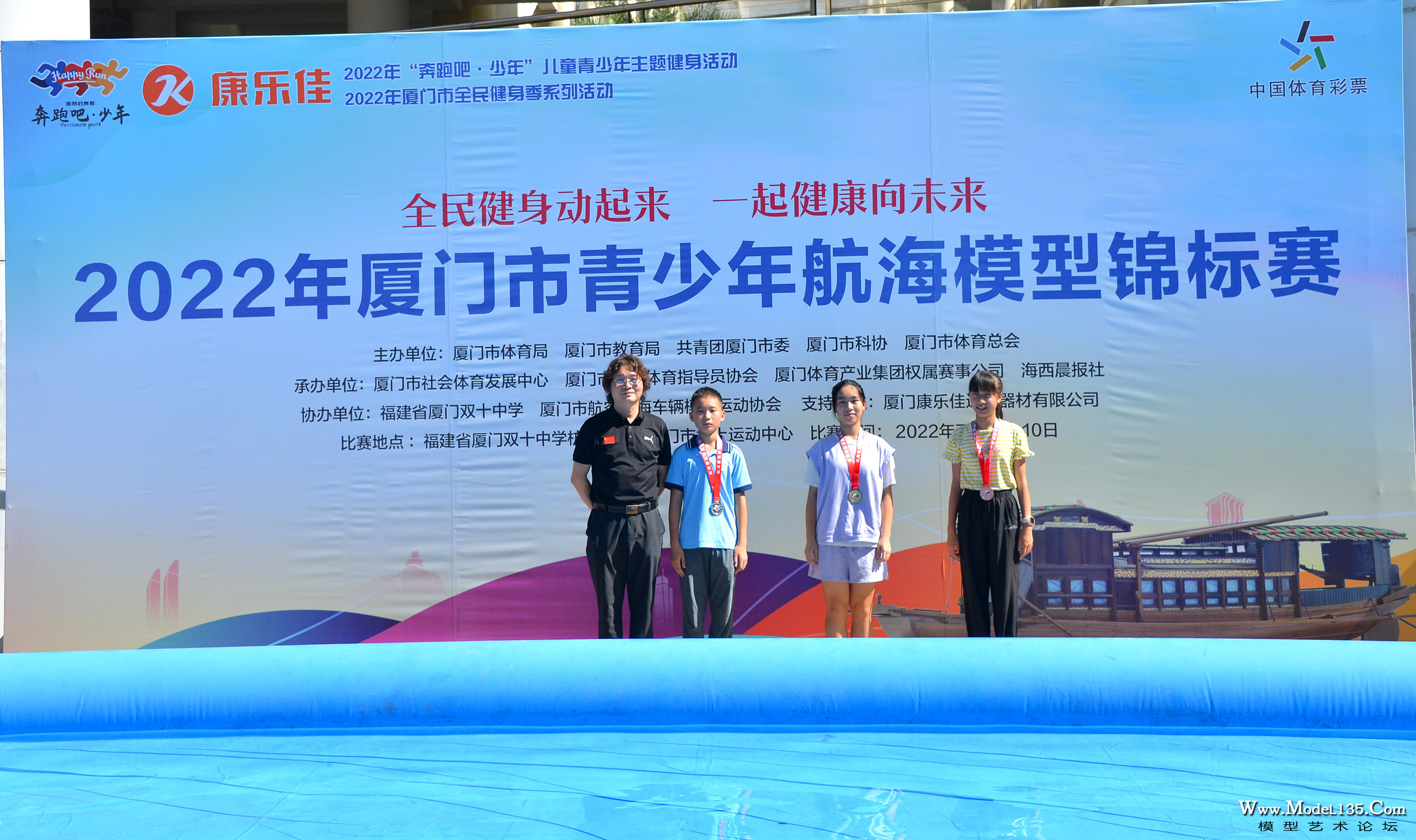 航海模型国际级裁判姜招银老师为获得大水池动力艇普及项目获奖选手颁奖